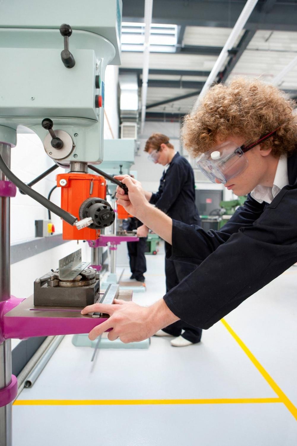 Elementary school student using a workshop drill during a young engineers club